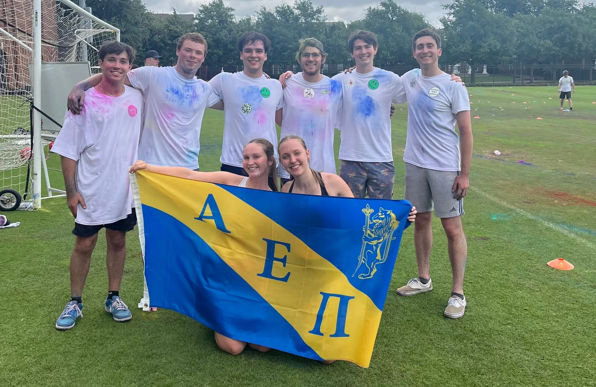 Tau Chi brothers holding the AEPi banner after an intramural match
