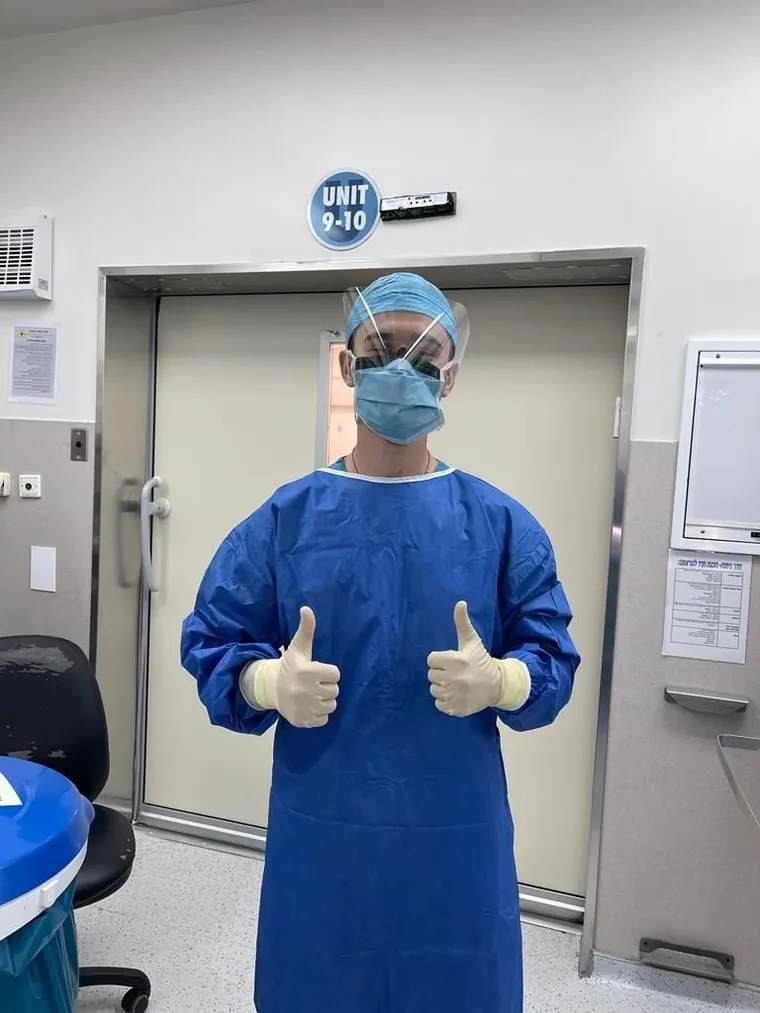 A Tau Chi brother volunteering in medical scrubs